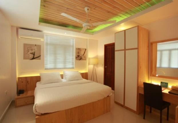 Superior Single room with a made-up bed, a wooden wardrobe, a desk and a window with blinds